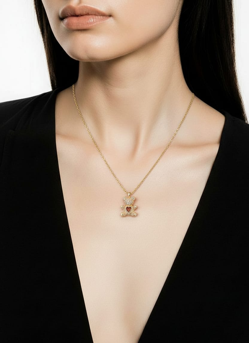 A woman in a black V-neck top showcases the Love Bear Necklace, a gold-plated titanium steel jewel featuring a teddy bear pendant with a red heart—perfect for fans of elegant women's jewelry.